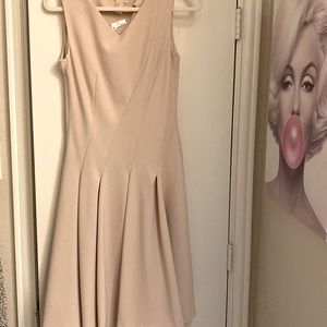 Nude dress fitted with pleats.